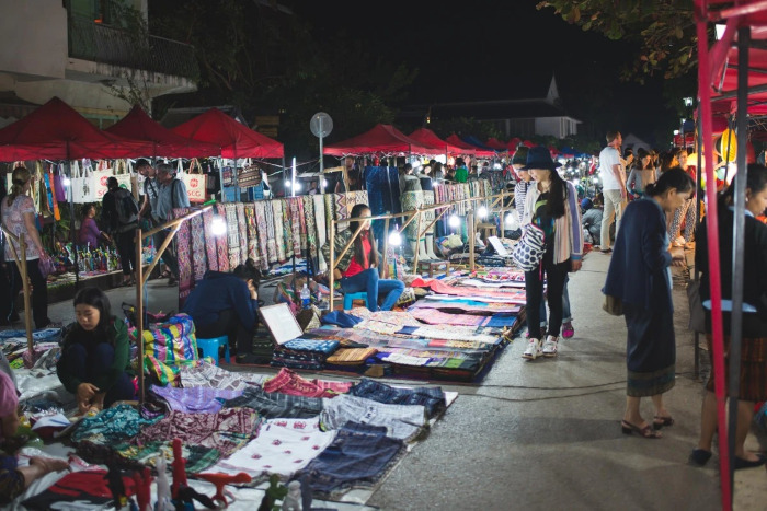 Promenez-vous dans le vibrant marché Luang Prabang de nuit, où des étals colorés proposent des souvenirs Luang Prabang uniques