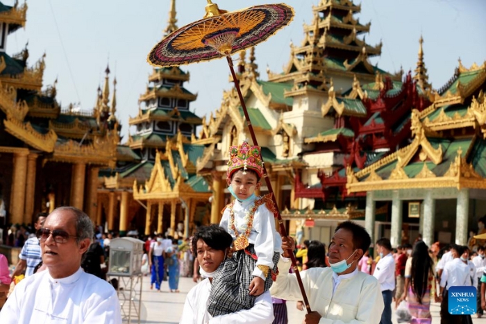 Des garçons en tenue traditionnelle assistent à la cérémonie de noviciat Shinbyu à la pagode Shwedagon à Rangoon, en Birmanie