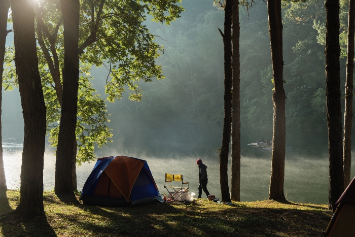 Faire du camping en pleine nature, sur la montagne, et admire le lac dans la brume au petit matin