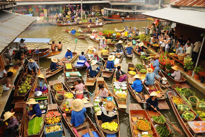 Bateaux colorés chargés de fruits tropicaux au marché flottant de Damnoen Saduak