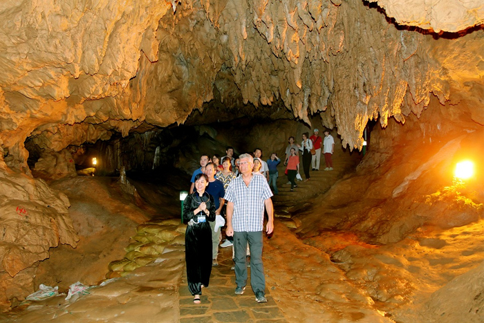 Les touristes explorent la grotte de Nguom Ngao