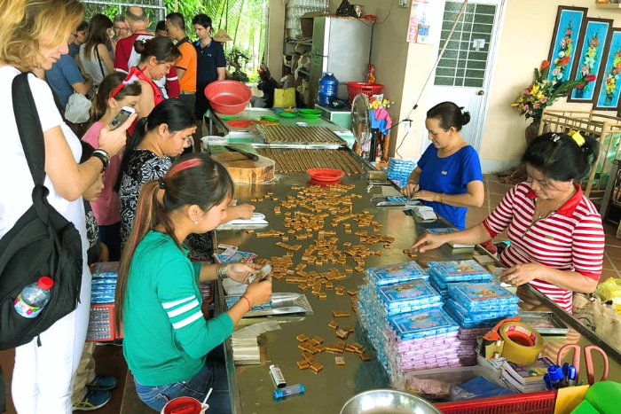 Moment convivial autour de la confection de bonbons à la noix de coco à Ben Tre
