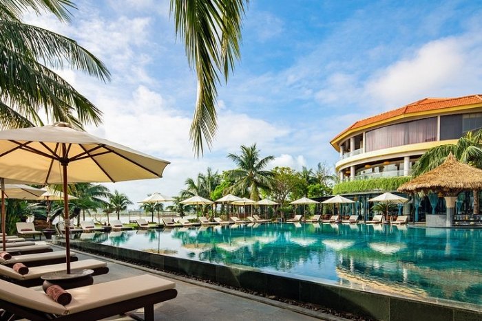 La piscine &agrave; d&eacute;bordement nich&eacute;e au c&oelig;ur d'un &eacute;crin de verdure du Bel Marina Hoi An Resort