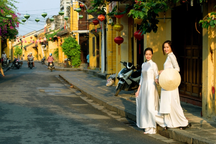 Charme vietnamien en áo dài dans les ruelles de Hoi An