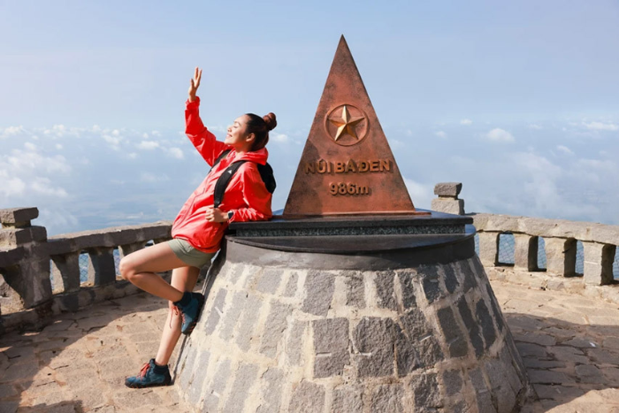 Un tourist prend des photos au sommet du mont Ba de la Vierge Noire