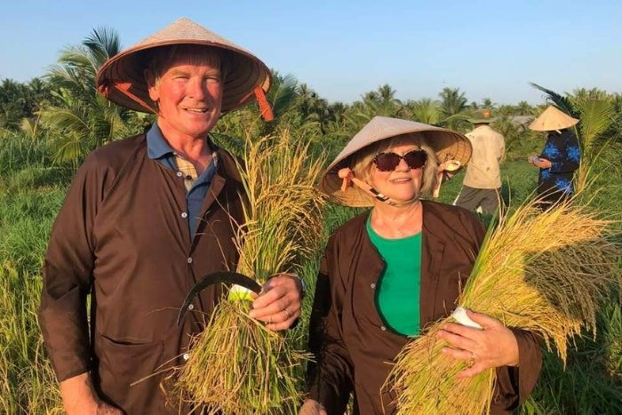 Les voyageurs appr&eacute;cient l&rsquo;exp&eacute;rience de la r&eacute;colte du riz aux c&ocirc;t&eacute;s des habitants locaux