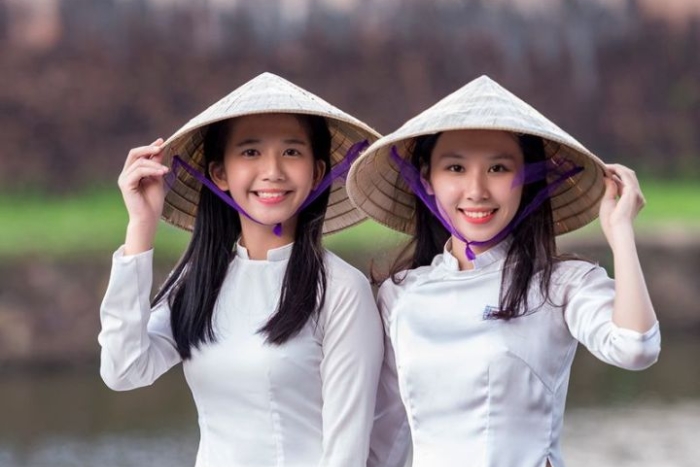 La simplicité et l'élégance des femmes vietnamiennes portant des chapeaux traditionnels