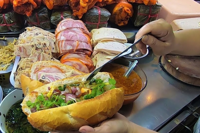 Pain vietnamien sous les mains habiles d'un vendeur de pain